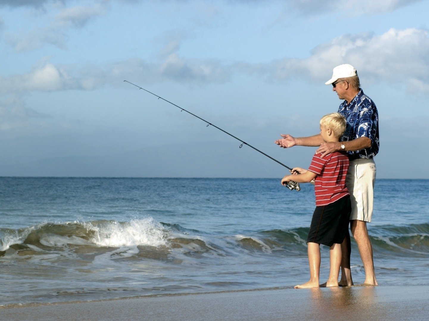 a father and son fishing on the beach