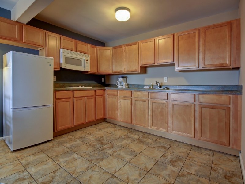 a kitchen with wooden cabinets and tile flooring