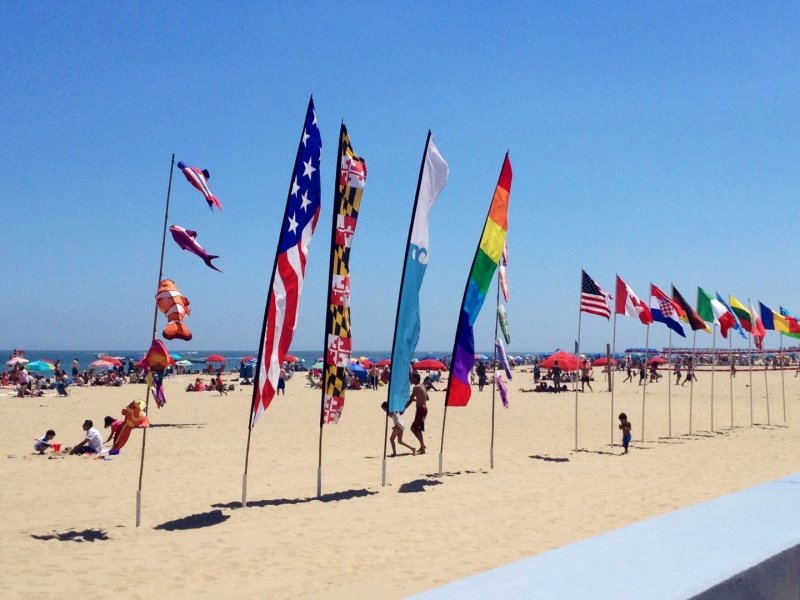 a beach with many flags and people on it